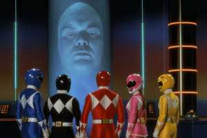 A imagem ilustra o post com o tema: Quem Era Zordon? A História do Mentor dos Power Rangers. A imagem mostra zordon em seu tubo na base dos power rangers conversando com os 5 rangers originais.